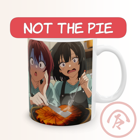 Anime funny mug featuring two girls in a chaotic cooking fail scene. One girl looks horrified while the other pokes a smoking, burnt pie with a spatula. Their shocked expressions and the dramatic kitchen disaster create a humorous, energetic anime moment. Full wrap print on a white ceramic mug, ideal for fans of comedic anime and baking mishaps.