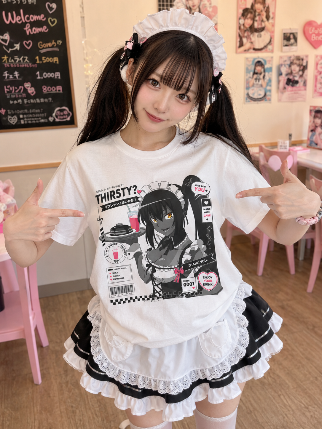 Japanese maid model wearing a white anime maid cafe T-shirt with cute manga graphic inside a pastel kawaii maid café.