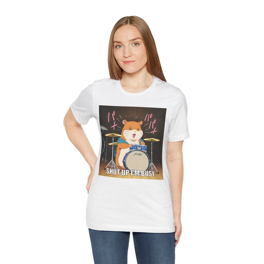 Funny hamster shirt with a cartoon hamster playing a full drum set, mid-solo, with motion lines and the bold caption “Shut up I’m busy.” The hamster wears a hoodie and looks adorably intense, printed clearly on a white unisex tee. Perfect for musicians, meme goblins, and anyone who needs a soft but firm “do not disturb” vibe. Loud in the best way — and undeniably cute.