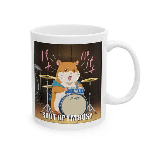Hamster meme mug featuring a cartoon-style kawaii hamster playing drums with dramatic intensity. The hamster looks determined and angry, mid-solo, with motion lines and the caption “Shut up I’m busy” at the bottom. Printed clearly on a white ceramic mug, this design is loud, funny, and emotionally feral. Perfect for office workers, meme lovers, and anyone who expresses stress through noise and adorable rage.